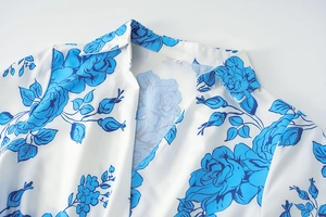 Détail du col classique et imprimé rose bleue sur tissu en mousseline blanche