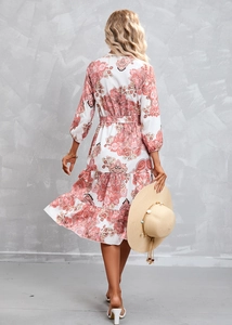 Detail view of the tiered skirt and bohemian paisley print on a white summer dress