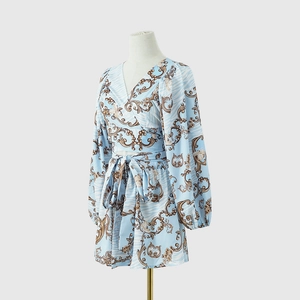 Detail of light blue floral wrap V-neck romper with gold baroque print and waist tie