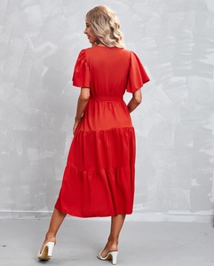 Detailed side view of a red tiered midi dress with ruffle sleeves and a tie-waist