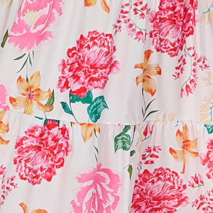 Macro detail of floral print fabric with pink peonies and orange lilies on white dress