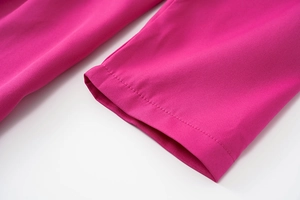 Close-up of hot pink dress sleeve with precise stitching and ribbed fabric texture