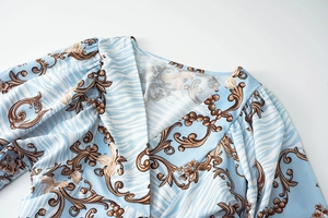 Detail of V-neck collar and shoulder with floral baroque print on blue fabric