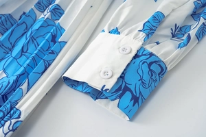 Détail du poignet d'une robe à imprimé floral bleu avec boutons blancs élégants