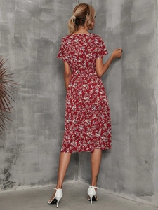 Detail of red floral dress showing waistline and white lace-up high heels back view