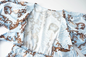 Close-up of blue floral v-neck romper featuring baroque patterns and zebra print details