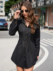 Detail shot of vintage bronze buttons on a black long-sleeved button-down dress