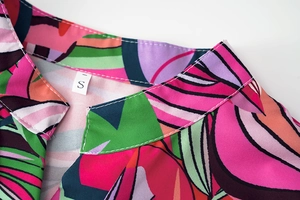 Détail de l'encolure d'une robe à imprimé tropical avec coutures soignées et étiquette taille S