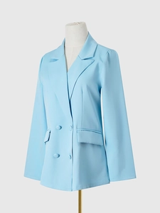 Détail d'un blazer croisé bleu ciel avec revers cranté et poches à rabat