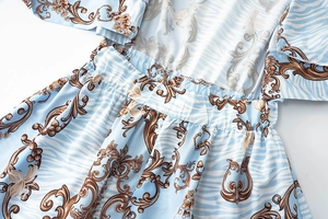 Detail view of floral baroque print and elastic waist on light blue women's romper