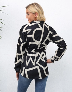 Detail of long sleeve shirt featuring black fabric with bold white geometric letter prints