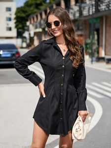 Detailed close-up of a black long-sleeve shirt dress with elegant gold button accents