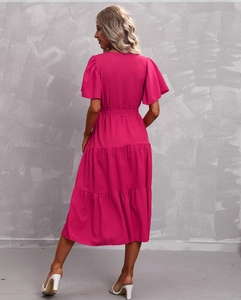 Detail of elegant magenta V-neck dress with layered ruffle skirt and matching waist belt