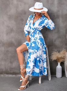 Détail de robe à fleurs avec fente haute et ourlet plissé sur un fond blanc