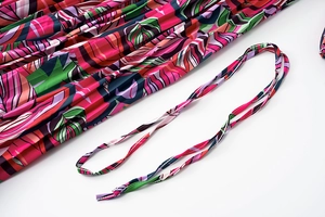Détail de robe plissée avec imprimé floral abstrait et ceinture assortie