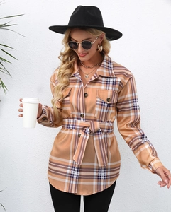 Detail of orange and white plaid flannel shacket with belt and flap chest pockets