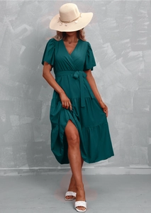 Detail of V-neck wrap dress featuring ruffle sleeves and a tiered skirt with tie waist