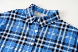 Primer plano del cuello de camisa a cuadros azul y botones blancos con etiqueta M