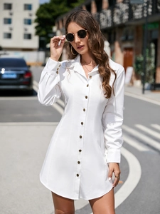 Detail of single-breasted black buttons on a white long-sleeve shirt dress with lapels