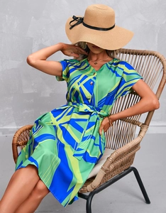 Detail of elegant V-neck dress featuring green and blue abstract geometric prints
