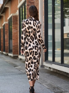 Street style view of a slim-fit zebra print midi dress with long sleeves and high neck