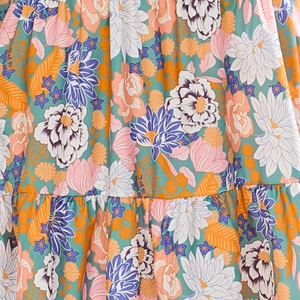 Detail of floral print fabric with pleats and smocked texture on a V-neck midi dress