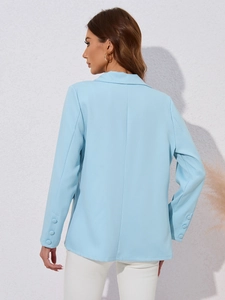 Vue détaillée du dos d'un blazer bleu clair à manches longues montrant le tissu et coutures