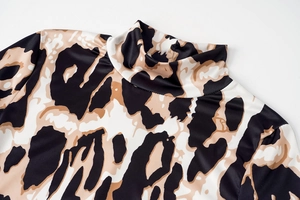 Macro shot of high-neck animal print dress featuring detailed stitching and fabric texture
