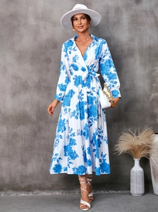 Détails de l'imprimé floral bleu et de la ceinture sur cette élégante robe longue blanche