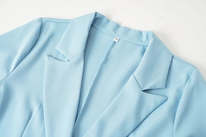 Détail du col d'un blazer bleu ciel avec étiquette de taille M sur le tissu tissé
