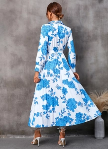 Détail d'une robe longue blanche à fleurs bleues et jupe plissée vue de l'arrière