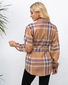 Detail of single-breasted plaid coat showing the matching waist belt and texture