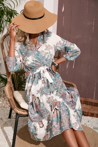 Detail of paisley print maxi dress featuring elegant V-neck and ruffled hemline