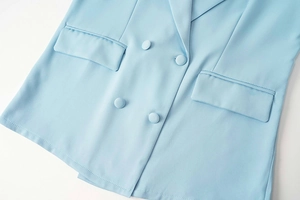 Détail du blazer croisé bleu clair avec boutons en tissu et poches à rabat