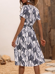 Detail of summer floral dress featuring elastic waist and deep V-neck back on white fabric