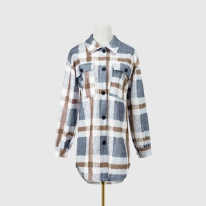 Detail view of long-sleeved plaid woolen coat with lapel collar and chest pockets