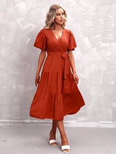 Detail of V-neck rust red tiered midi dress with ruffle sleeves and waist tie design