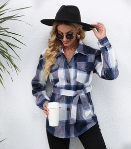 Detail of blue and white plaid coat with chest pockets and adjustable waist belt