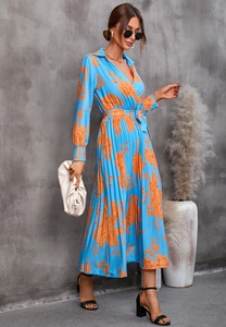 Détail d'une robe bleue à manches longues avec imprimé floral orange et jupe plissée