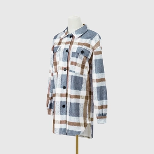 Detail of plaid shacket featuring double flap chest pockets and curved high-low hemline