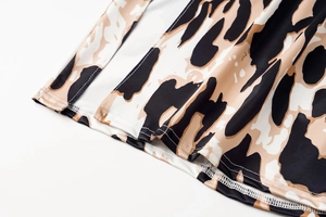 Detailed close-up of zebra print fabric with high-quality stitching on the split hemline