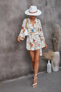 Detail of luxury gold chain and seashell print on a white V-neck long sleeve romper
