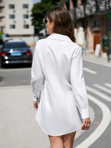 Detail shot of white long-sleeve shirt dress showing the back slim fit and buttoned cuffs