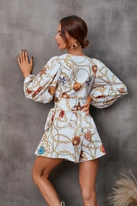 Rear view of white V-neck romper with gold nautical chain and shell print details