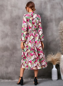Vue détaillée d'une femme en robe midi à manches longues avec imprimé feuilles d'automne