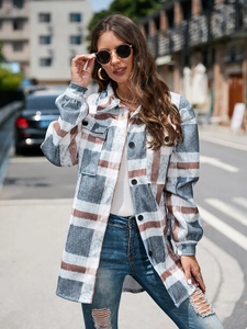 Close-up of blue and brown plaid wool coat with breast pockets and button closure
