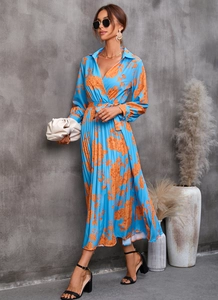 Détail de la robe plissée bleue à col en V avec imprimé rose orange et ceinture