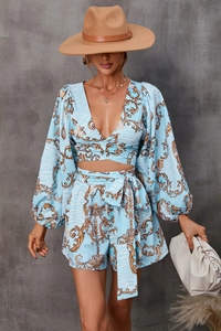 Detail of V-neck lantern sleeve top with blue and gold baroque floral print