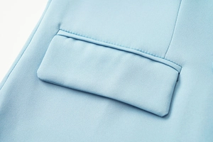 Détail de tissu texturé bleu clair avec poche à rabat et coutures professionnelles