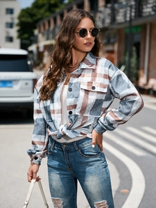 Detail shot of a long-sleeved plaid shacket with chest pockets and a front knot styling